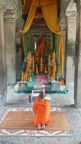 Buddhist-munk som ber inne i Angkor Wat